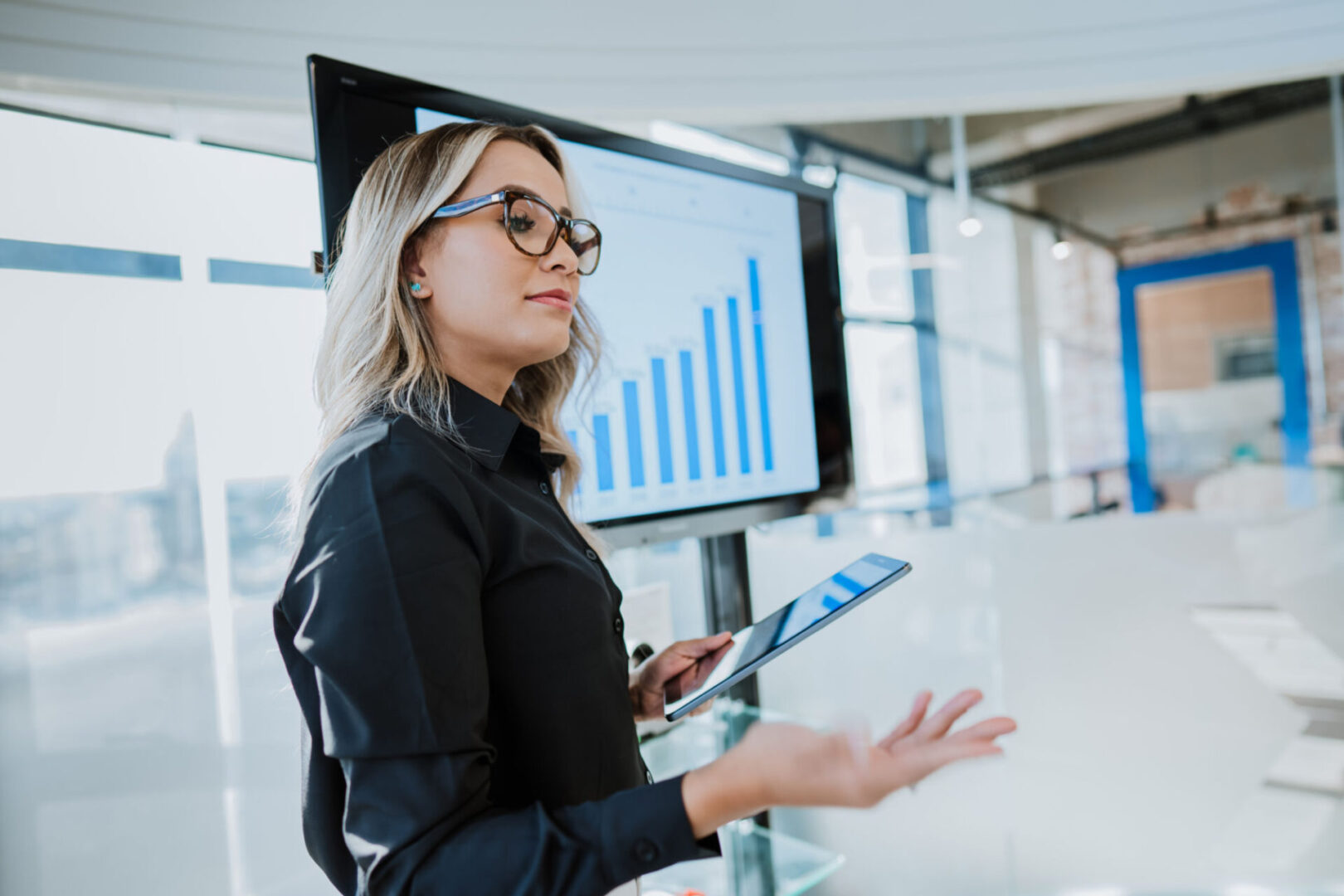 Woman presenting data with charts in a modern office.