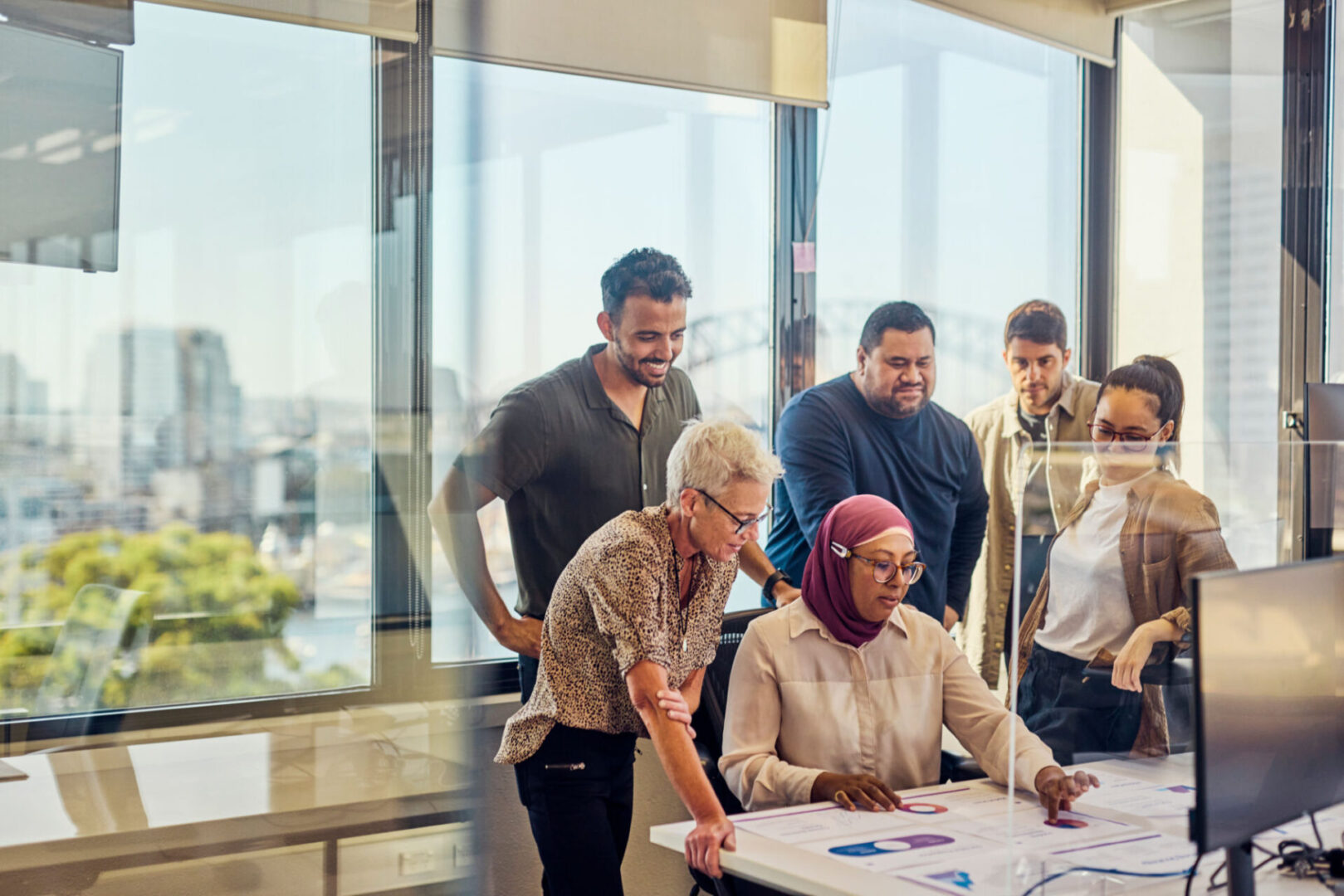 A diverse team collaborates on a project in a modern office.
